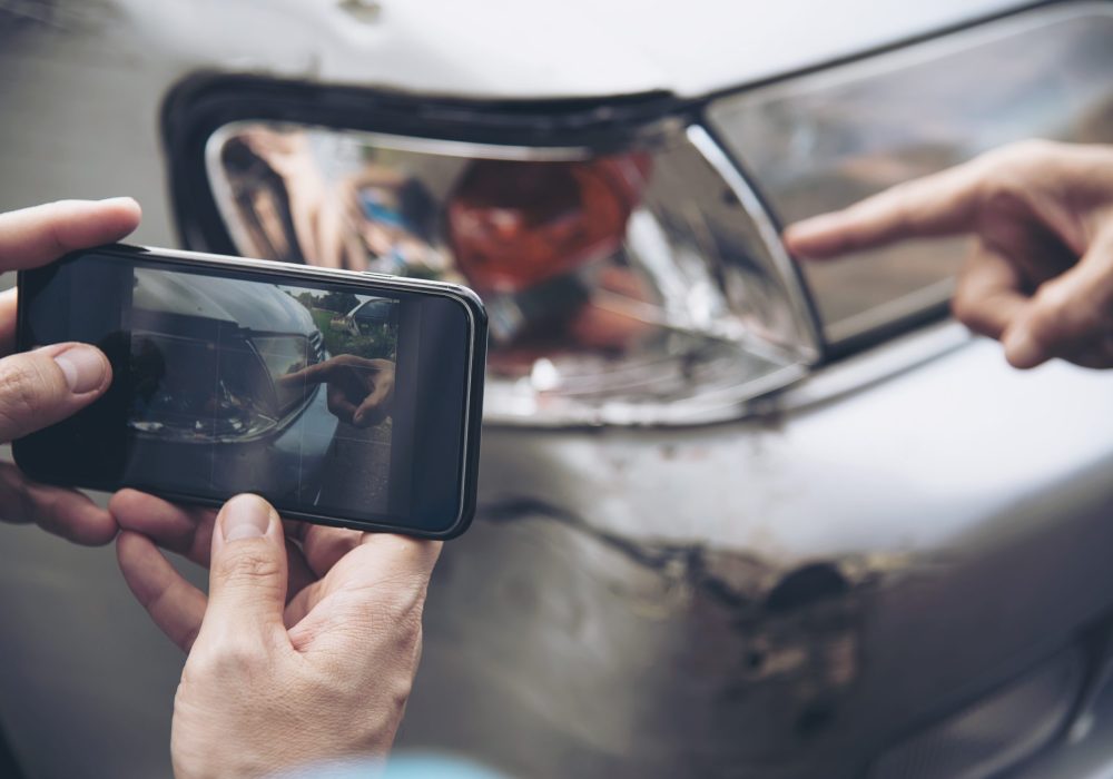 Insurance agent working during on site car accident claim process - people and car insurance claim concept