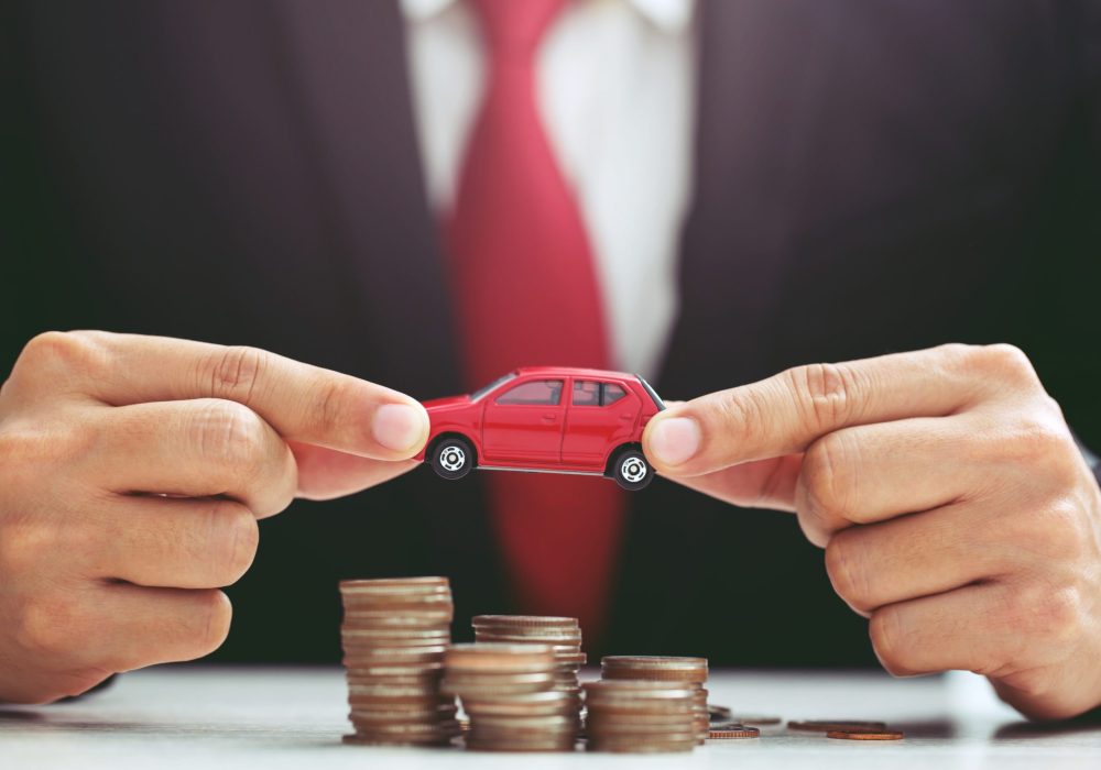 Business man in suit open hand prop up hug model of toy car on over a lot money of stacked coin insurance loan and buying car finance concept. buy and installment down payment a car. Piggy Bank saving